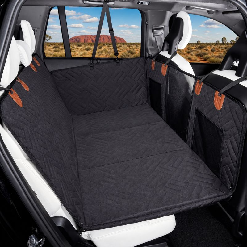Car seat cover with a patterned design installed in a vehicle, showing a scenic view outside.