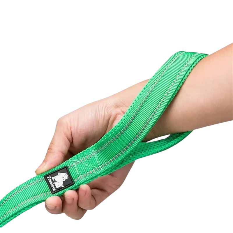 Green dog leash held by a hand with a brand label on a white background
